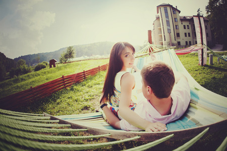 A look from behind on the couple lying on a hammock in a sunny dayの写真素材