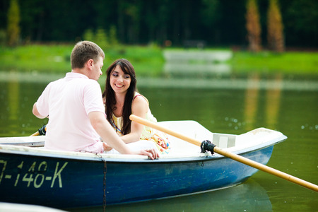 Smiling brunette lady hugs her man while floating in the boatの写真素材