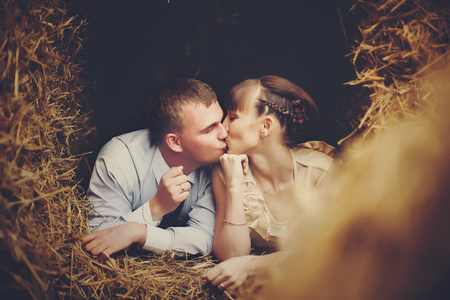 Kissing couple rests on the hayの写真素材