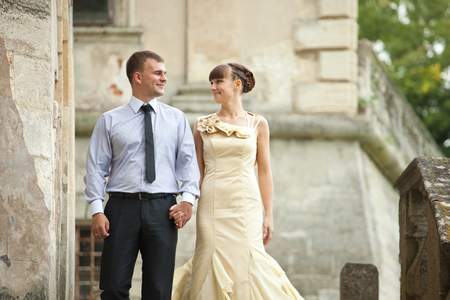 Happy man holds woman's hand standing on the ruinsの写真素材