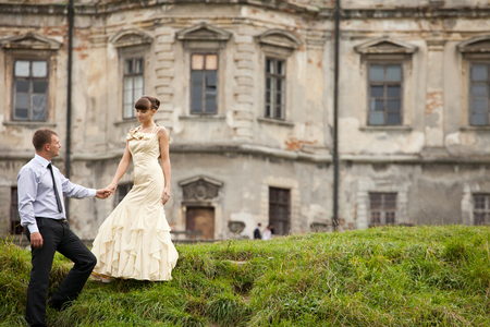 Gorgeous lady in evening gown walks down on the green hillの写真素材