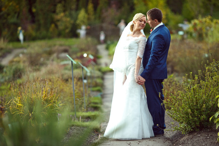 Groom admires a dreamy bride looking at him over her shoulderの写真素材