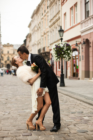 Groom kisses passionately a bride in short dressの写真素材
