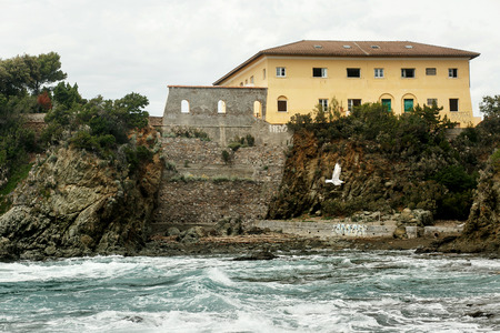 View from the sea water on the ruined house standing on the coastの写真素材