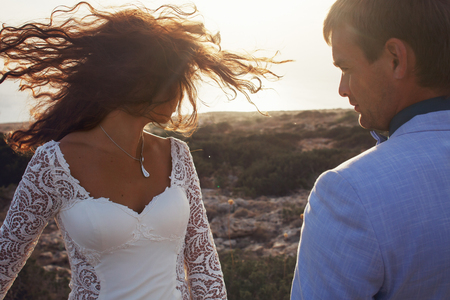 Man admires a woman in white gown while she shakes her hairの写真素材