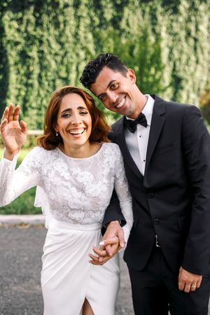 Italian style newlyweds laugh while standing in the parkの写真素材