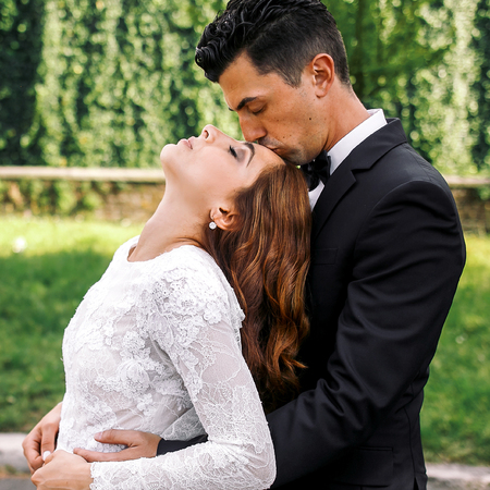 Bride throws her head back and groom kisses her foreheadの写真素材