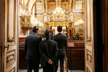 Jewes in hats walk into the bright synagogueのeditorial素材