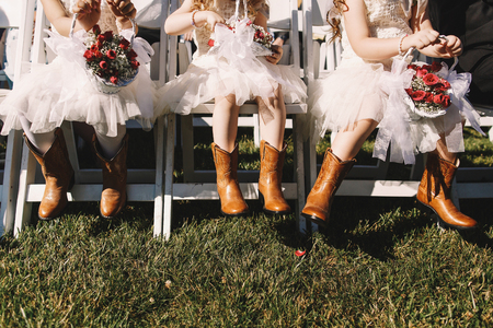 Little bridesmaids in white dresses and leather boots