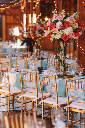 Wooden chairs stand at the tables covered with blue clothの写真素材