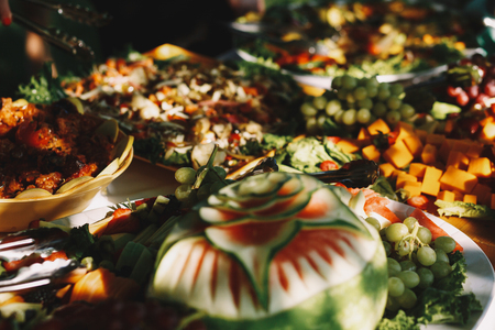 Cut fruits stand on the table in trees shadowsの写真素材