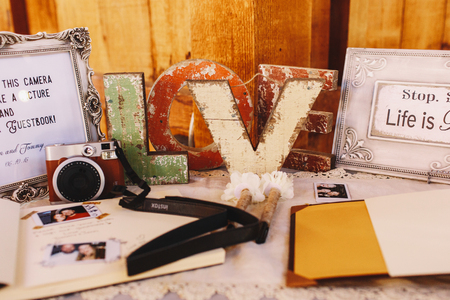 Old wooden letters LOVE stand between beautiful frames around wishbooksの写真素材