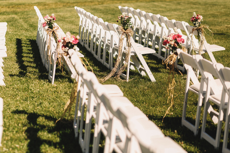 White chairs stand in long rows waiting for the beginning of wedding ceremonyの写真素材