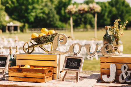 Wooden letterings 'Love' stand between the wooden boxes with lemons on the tableの写真素材