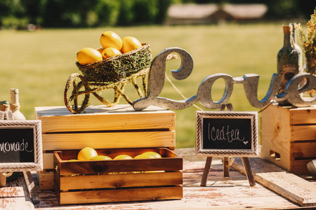 Wheelbarrow made of greenery stands over the wooden box as a part of wedding decorの写真素材
