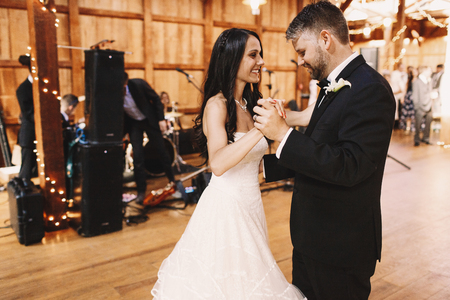 Groom steps carefull while dancing with attractive brunette brideの写真素材
