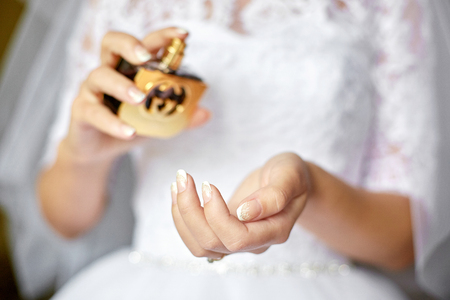 Beautiful bride sprays magnificent parfume on her wirstの写真素材