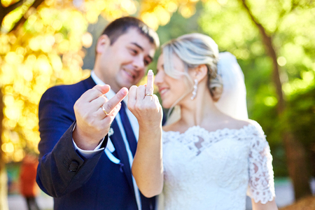Closeup of fingers with wedding rings shown by newlywedsの写真素材