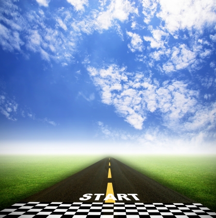 road and starting point on grass field with skyの写真素材