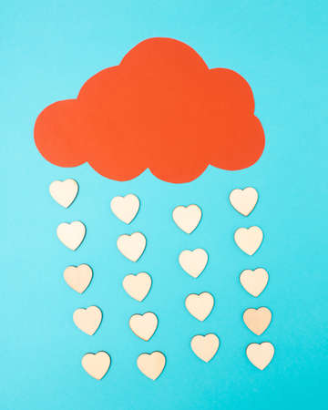 Rain of hearts. Concept of Valentineâs Day from made of a blue background and a red cloud from which hearts fall.の写真素材