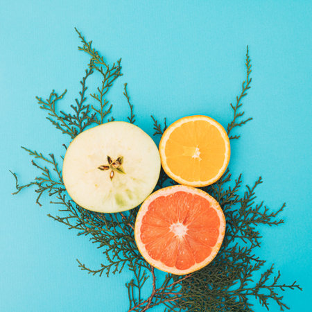 Summer organic fruit scene on cyan blackground. Flat lay minimalictic concept with fruit and green branch.の写真素材
