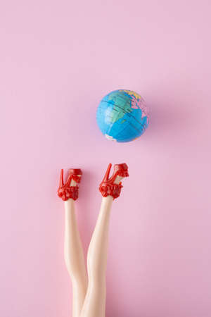 Geographical globe kick a womans foot Minimal global concept on pink background.の写真素材