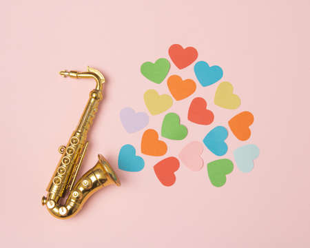Golden saxophone from which hearts of different colors come outの写真素材