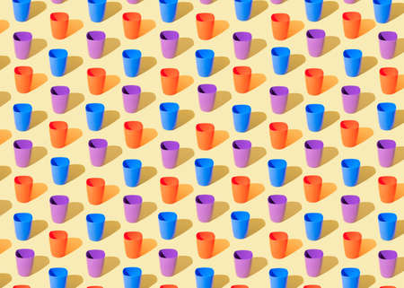 Pattern made of blue, purple and red plastic cups with a shadow on a light yellow backgroundの写真素材