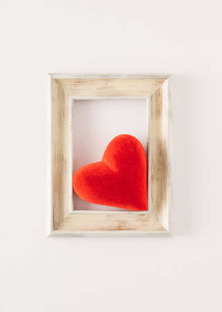 Plush red heart in a rectangular frame. Minimalist concept of Valentine's Dayの写真素材