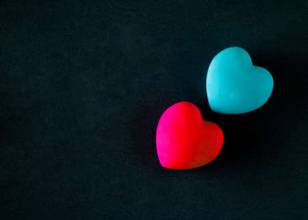 Blue and red heart on a black background. Empty copy space.Minimalist concept of a day of loveの写真素材
