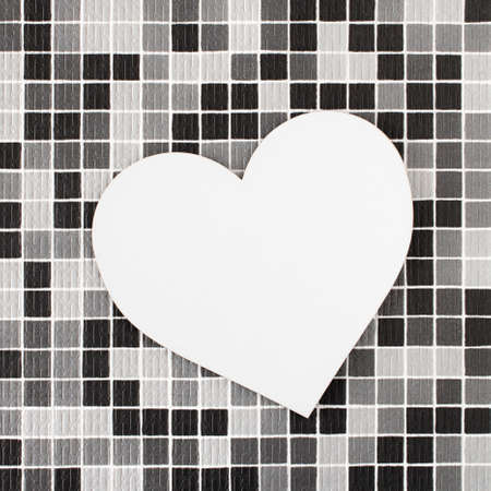 Big white heart on a checkered background of black, white and gray squares. Minimal concept of Valentine's Day.  Empty spaceの写真素材