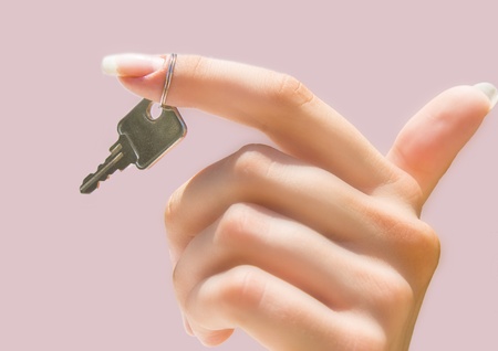 Beautiful hand holding a key on pinkの写真素材