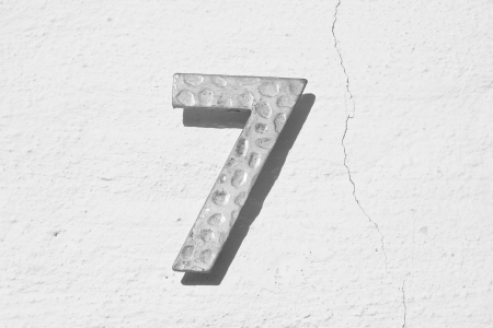 Number seven on an old white cracked wallの写真素材