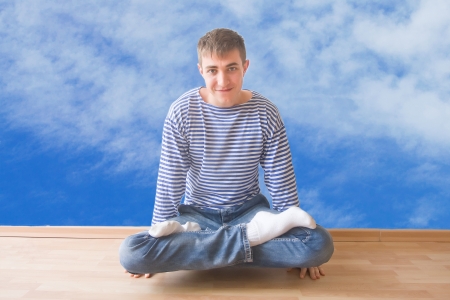 Smiling young man doing yoga excercises on edgeの写真素材