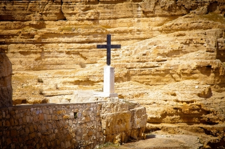 Old rude metal cross put in a desert valley to mark a place of a hermit