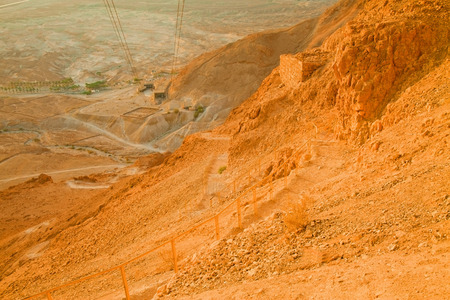 View of the the valley laying under the Snake Path ascend to Massada Fortress (Israel) at dawn (unusual desert sunrise lighting)の写真素材