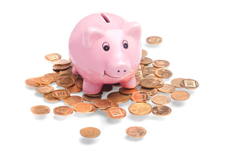 Pig-shaped money box standing on golden coinsの写真素材