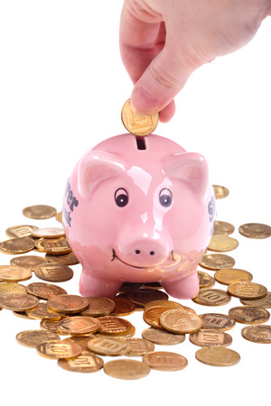 Putting money in the piggy-box - banking and savings concept (isolated over white)の写真素材