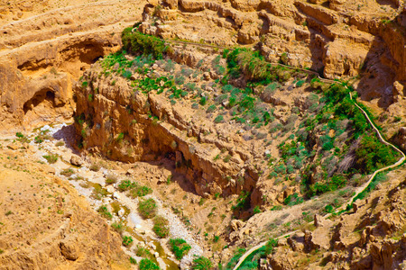 Stony desert valley with an ancient aqueduct and grass near itの写真素材
