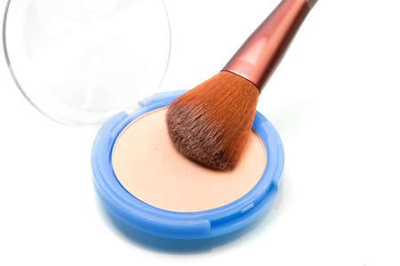 Large powder brush picking powder from a palette (over white surface with reflection)の写真素材
