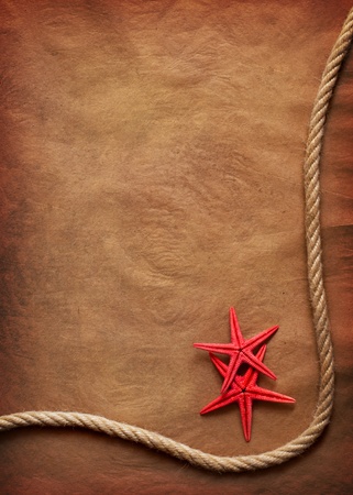 Aged Rope and starfish on the old paper backgroundの写真素材