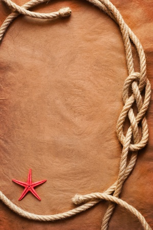 Aged Rope and starfish on the old paper backgroundの写真素材