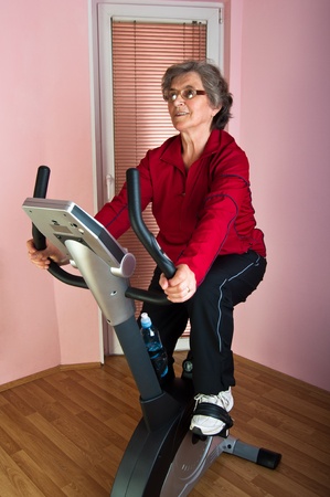 happy senior woman exercise on spinning bicycle at homeの写真素材
