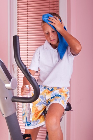 happy boy exercise on spinning bicycle at homeの写真素材