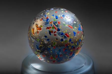 Colors in a crystal ball on a stand on gray backgroundの写真素材