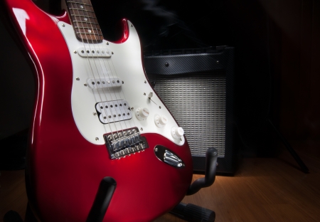 red and white electric guitar and combo amplifier on black background の写真素材