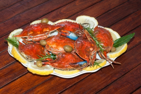 Dish with cooked crabs and lemon, olive and rosemaryの写真素材