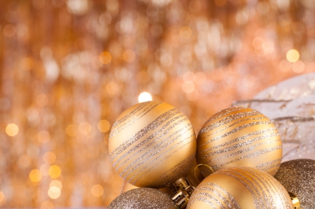 gold christmas baubles on background of defocused golden lights.の写真素材