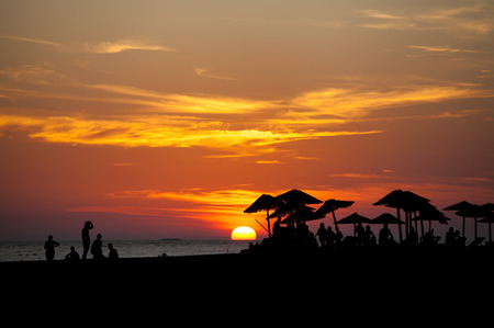 beautiful beach silhouettes of palm beach umbrella at sunsetの写真素材