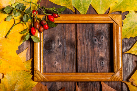 Vintage autumn fallen leaves and picture frame on the old wooden tableの写真素材